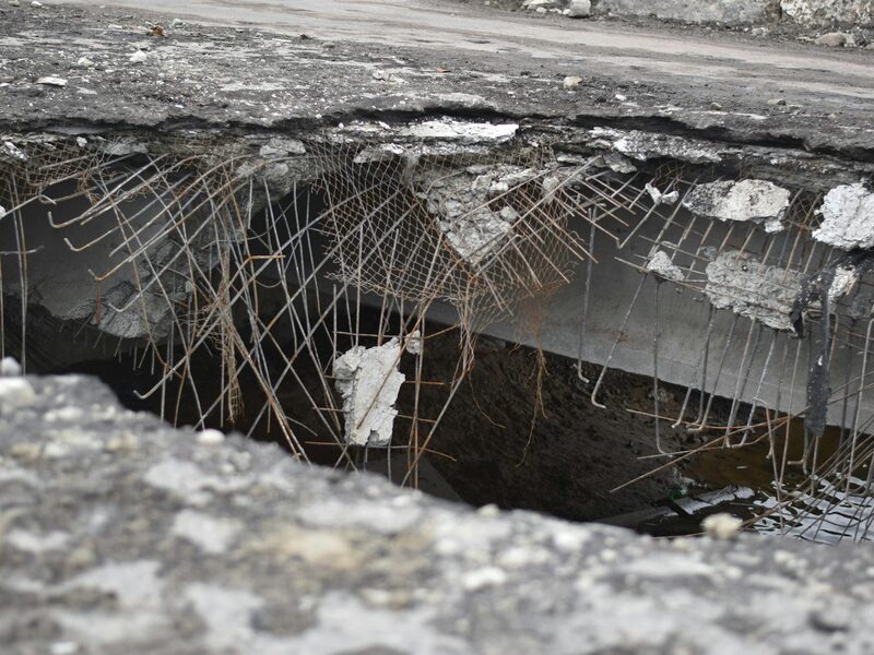 Cracked, pitted asphalt with potholes before repair