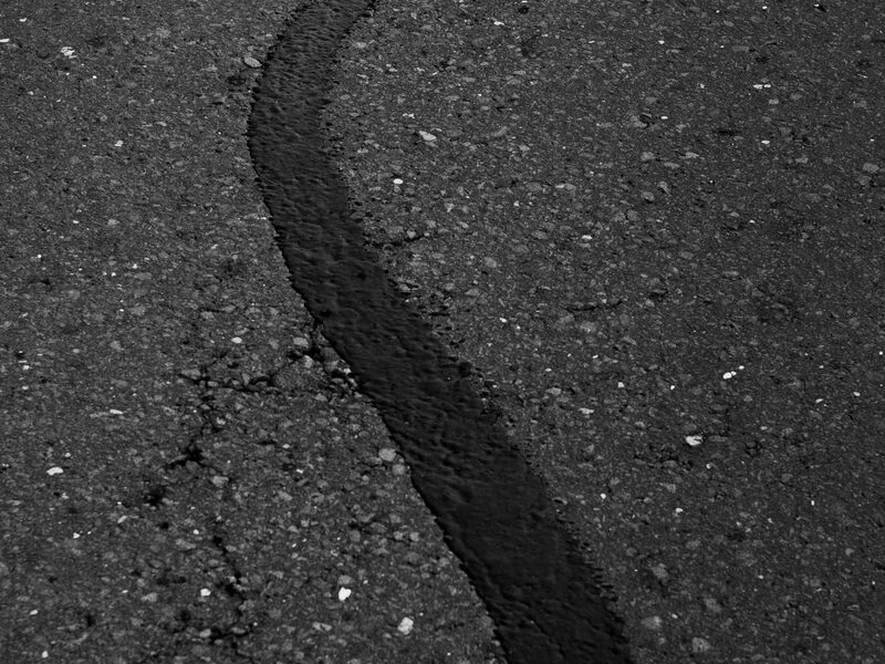 Asphalt with sealed cracks after hot-pour crack seal