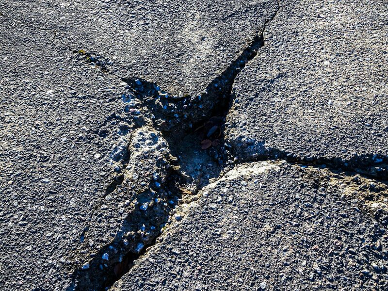 Asphalt surface with visible cracking before sealant application