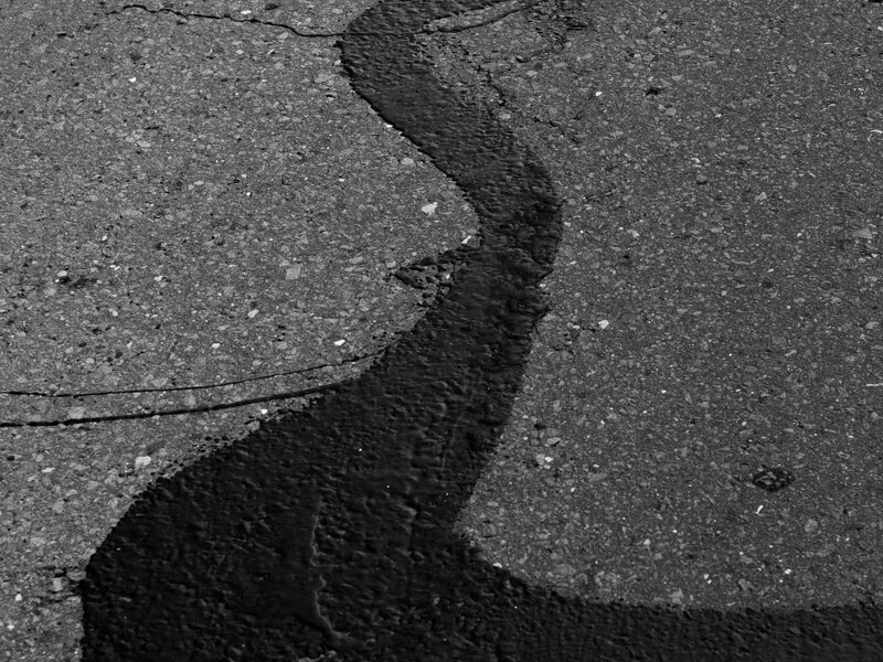 Oxidized gray asphalt with surface weathering before seal coat