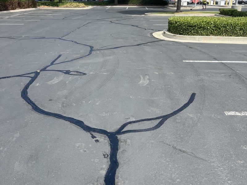 Fresh hot-pour crack seal on a commercial parking lot