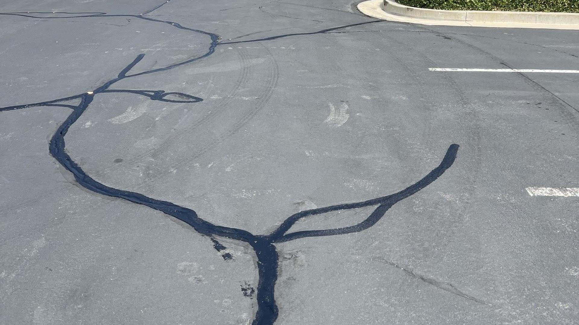 Fresh hot-pour crack seal on a commercial parking lot
