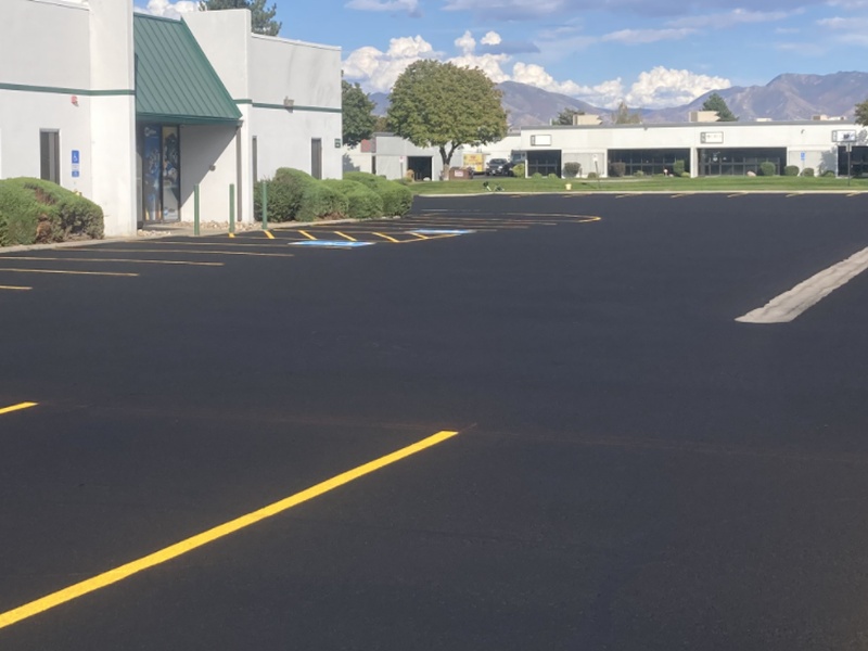 Freshly seal-coated parking lot with new yellow striping